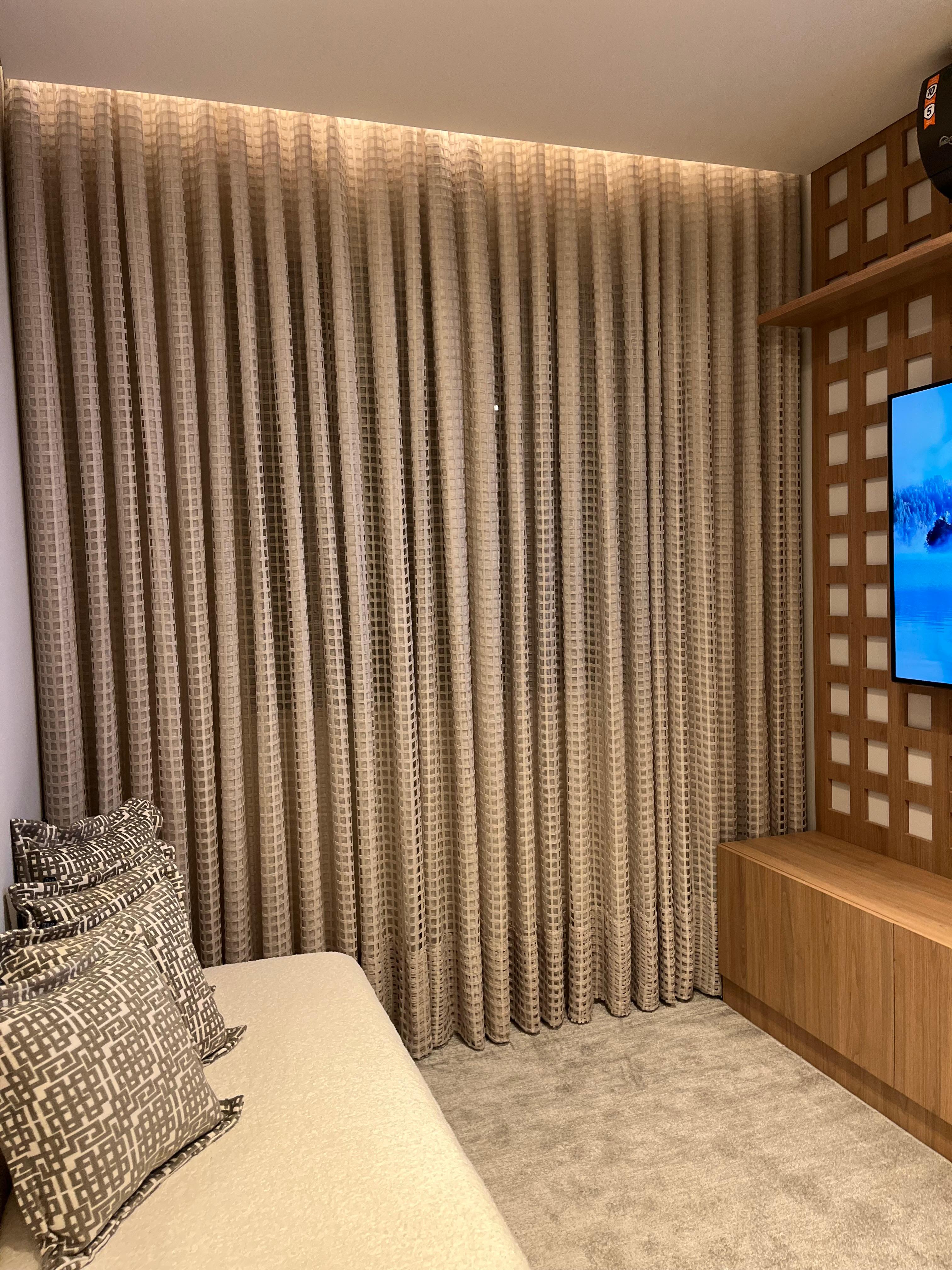 Cortina com textura em tom neutro em quarto planejado com TV